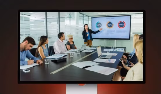 Profissionais em uma sala de reunião com uma apresentação de PowerPoint.